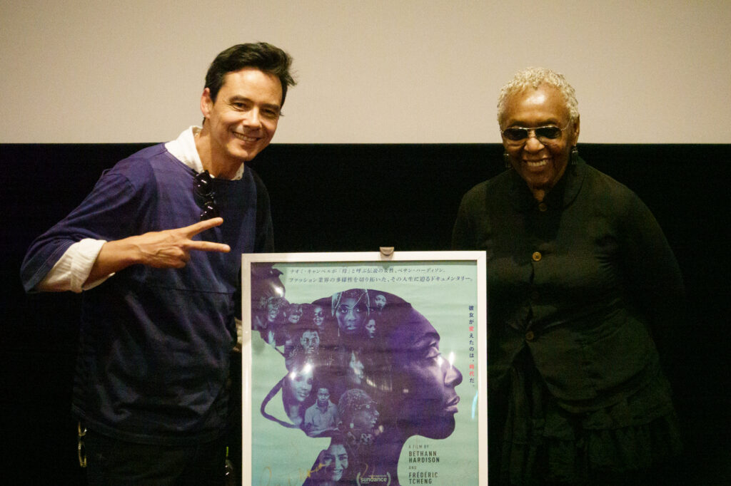 ポスターの前でポーズを取るフレデリック・チェンとベサン・ハーディソン